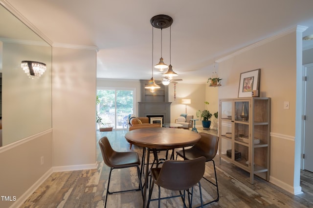 5514 Oldtowne Rd, Raleigh, NC 27612 - dining area with a fireplace, wood finished floors, ornamental molding, and baseboards