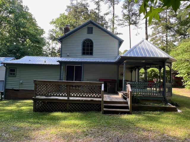358 Pool Rock Shores Ln, Henderson, NC 27537 - rear view of house with a yard, a chimney, metal roof, and a deck