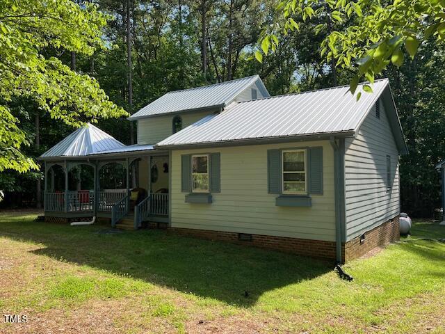 358 Pool Rock Shores Ln, Henderson, NC 27537 - view of front facade featuring crawl space, a front yard, a porch, and metal roof