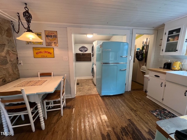 358 Pool Rock Shores Ln, Henderson, NC 27537 - kitchen featuring fridge, stacked washing machine and dryer, dark wood-type flooring, white cabinets, and light countertops