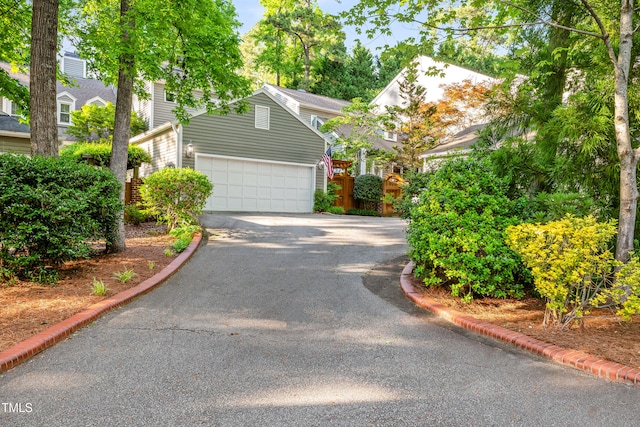 2205 Landings Way, Raleigh, NC 27615 - view of property hidden behind natural elements with asphalt driveway and a garage