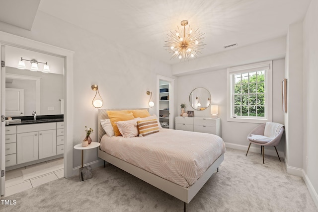 129 Ruskin Dr, Chapel Hill, NC 27516 - bedroom with a chandelier, a sink, connected bathroom, light carpet, and a walk in closet