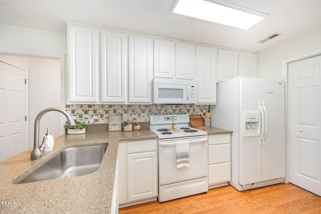 1851 Trailwood Heights Ln Unit 204, Raleigh, NC 27603 - kitchen featuring white appliances, white cabinets, and tasteful backsplash