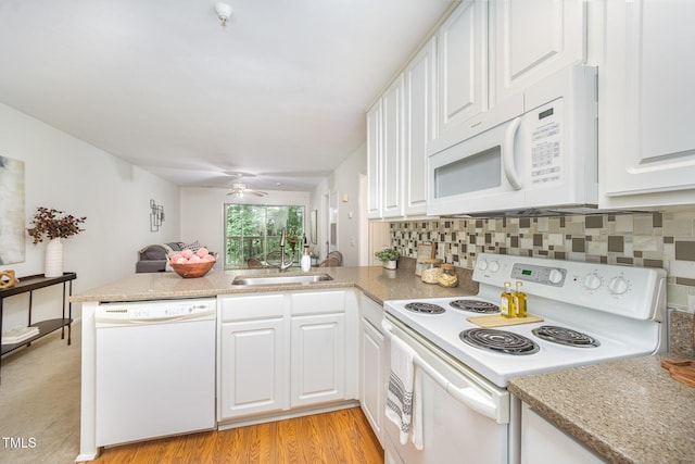 1851 Trailwood Heights Ln Unit 204, Raleigh, NC 27603 - kitchen featuring white appliances, a peninsula, white cabinetry, and backsplash