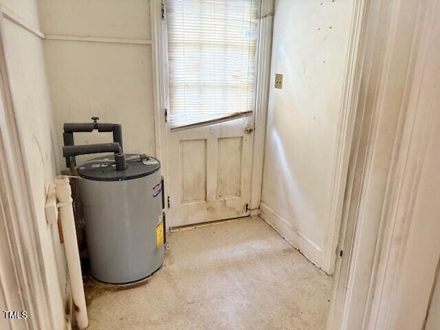 doorway featuring water heater and light carpet