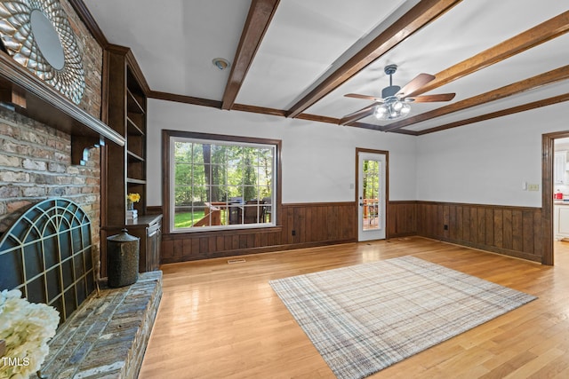 2840 Mattlyn Ct, Raleigh, NC 27613 - unfurnished living room featuring wainscoting, light wood-type flooring, beam ceiling, plenty of natural light, and ceiling fan