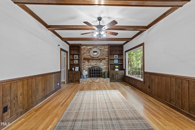 2840 Mattlyn Ct, Raleigh, NC 27613 - unfurnished living room with wainscoting, light wood finished floors, beamed ceiling, ceiling fan, and a fireplace