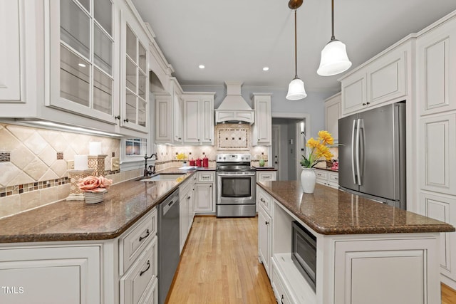 2840 Mattlyn Ct, Raleigh, NC 27613 - kitchen with stainless steel appliances, custom exhaust hood, a sink, a kitchen island, and tasteful backsplash
