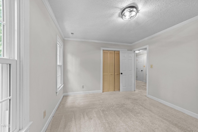 2840 Mattlyn Ct, Raleigh, NC 27613 - unfurnished bedroom featuring a textured ceiling, crown molding, a closet, carpet flooring, and baseboards