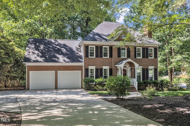 2125 Oakcrest Ct, Raleigh, NC 27612 - view of front of home featuring an attached garage, a chimney, brick siding, and driveway