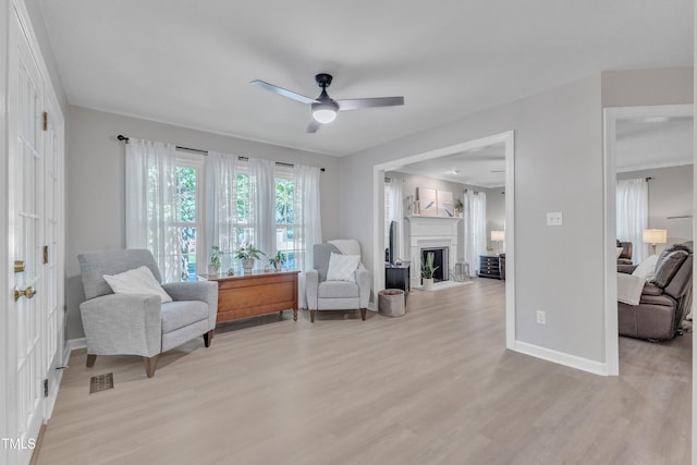 2125 Oakcrest Ct, Raleigh, NC 27612 - sitting room with a ceiling fan, light wood-type flooring, baseboards, and a fireplace