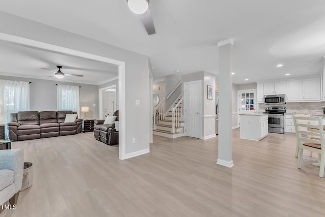 2125 Oakcrest Ct, Raleigh, NC 27612 - living room with a ceiling fan, stairway, light wood finished floors, baseboards, and recessed lighting