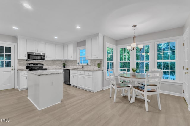 2125 Oakcrest Ct, Raleigh, NC 27612 - kitchen featuring appliances with stainless steel finishes, a sink, decorative backsplash, white cabinetry, and light wood-style floors
