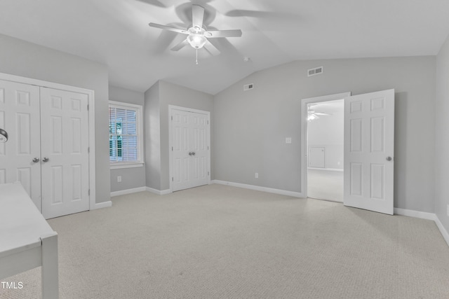 2125 Oakcrest Ct, Raleigh, NC 27612 - unfurnished bedroom featuring two closets, light carpet, lofted ceiling, baseboards, and a ceiling fan