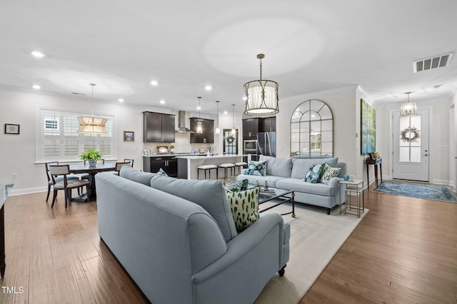 1010 Sandbar Ln, Durham, NC 27703 - living room with crown molding, plenty of natural light, recessed lighting, wood finished floors, and baseboards