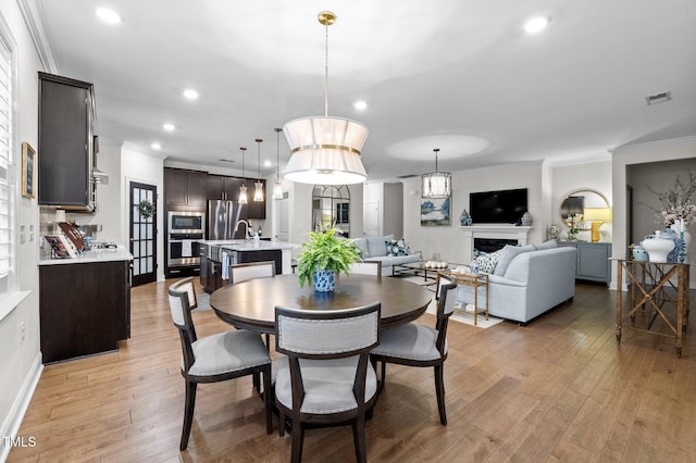 1010 Sandbar Ln, Durham, NC 27703 - dining room with ornamental molding, light wood-style flooring, recessed lighting, and a fireplace