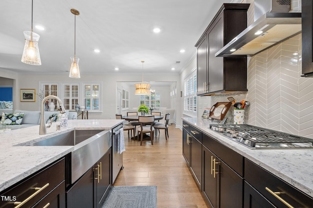 1010 Sandbar Ln, Durham, NC 27703 - kitchen featuring wall chimney range hood, stainless steel appliances, ornamental molding, plenty of natural light, and a sink
