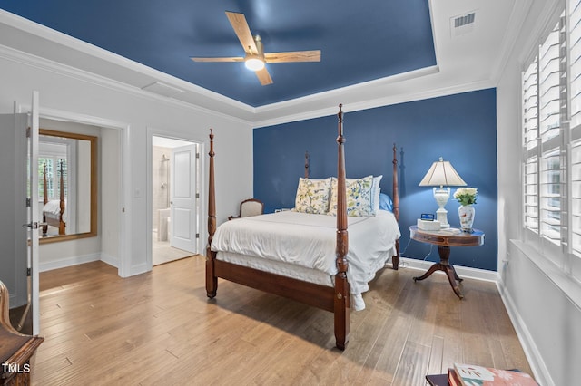 1010 Sandbar Ln, Durham, NC 27703 - bedroom with wood finished floors, baseboards, ensuite bathroom, ornamental molding, and a tray ceiling