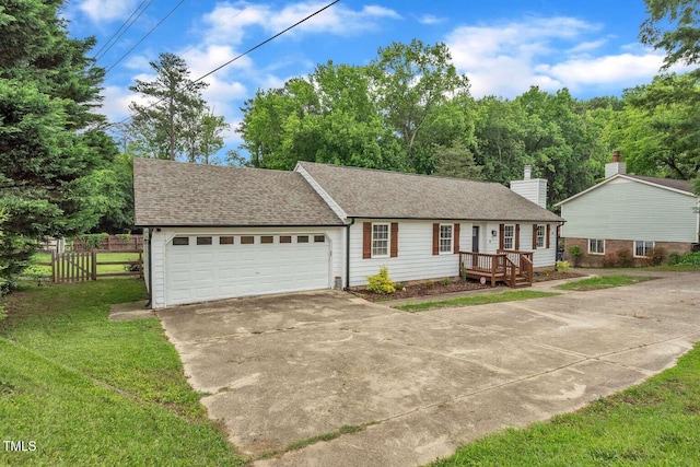 view of front of home featuring driveway, a garage, roof with shingles, and a chimney