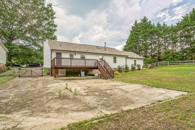 back of property featuring a gate, a deck, a chimney, stairway, and a patio