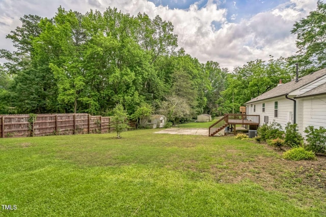 view of yard with a deck, an outdoor structure, central air condition unit, and a patio