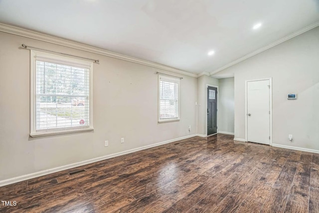 empty room with plenty of natural light, wood finished floors, crown molding, lofted ceiling, and baseboards