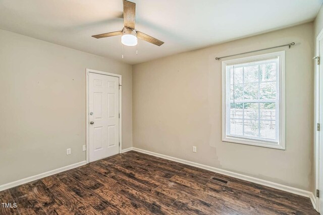 spare room with dark wood finished floors, ceiling fan, and baseboards
