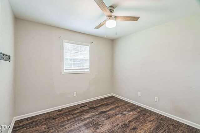 unfurnished room with dark wood-style flooring, baseboards, and ceiling fan