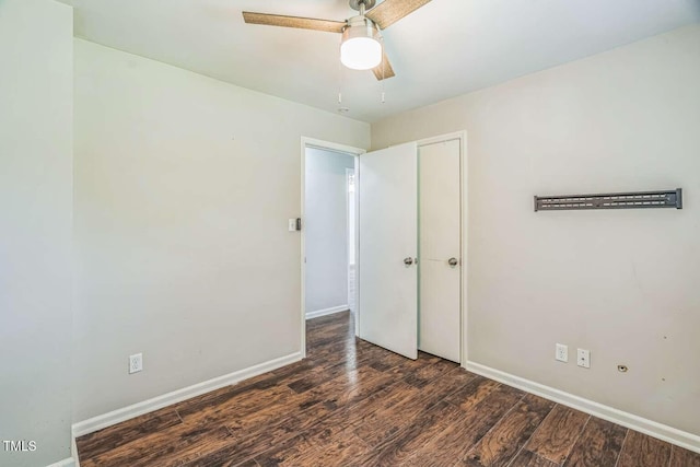 spare room with wood finished floors, baseboards, and a ceiling fan