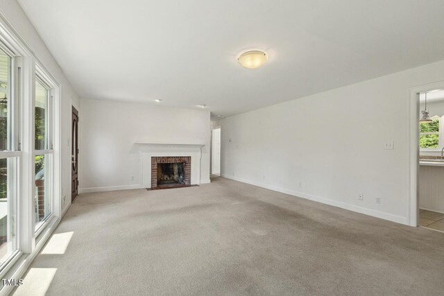 418 S W St, Cary, NC 27511 - unfurnished living room featuring light colored carpet, a fireplace, baseboards, and a sink
