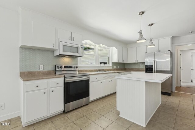 418 S W St, Cary, NC 27511 - kitchen featuring appliances with stainless steel finishes, a sink, tasteful backsplash, white cabinets, and light countertops