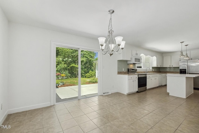 418 S W St, Cary, NC 27511 - kitchen with stainless steel appliances, a chandelier, white cabinetry, a sink, and hanging light fixtures
