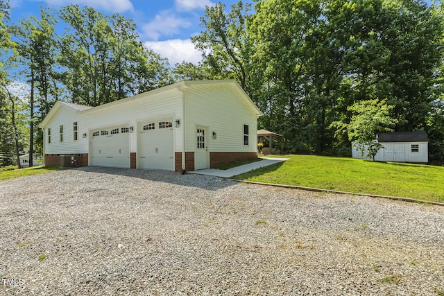 418 S W St, Cary, NC 27511 - view of side of property with central AC unit, gravel driveway, an attached garage, and a lawn