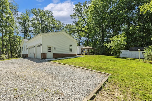 418 S W St, Cary, NC 27511 - view of side of home with driveway, a yard, an attached garage, brick siding, and an outbuilding