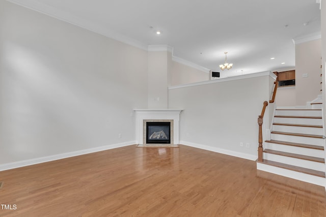 9211 Calabria Dr Unit 104, Raleigh, NC 27617 - unfurnished living room with crown molding, a chandelier, light wood-type flooring, a fireplace with flush hearth, and stairs