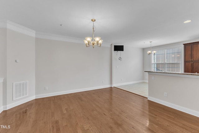 9211 Calabria Dr Unit 104, Raleigh, NC 27617 - unfurnished room with a chandelier, light wood-style floors, baseboards, and ornamental molding