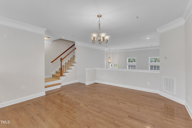 9211 Calabria Dr Unit 104, Raleigh, NC 27617 - empty room featuring crown molding, wood finished floors, a chandelier, baseboards, and stairs