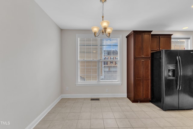 9211 Calabria Dr Unit 104, Raleigh, NC 27617 - kitchen with black fridge, a chandelier, baseboards, and pendant lighting