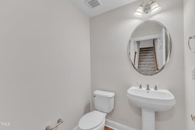 9211 Calabria Dr Unit 104, Raleigh, NC 27617 - half bath featuring toilet, baseboards, and a sink