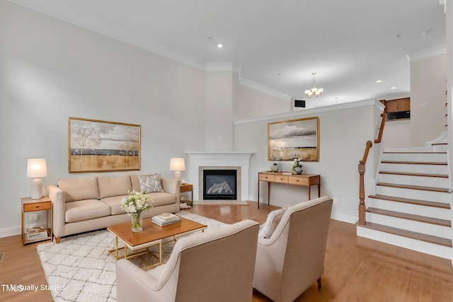 9211 Calabria Dr Unit 104, Raleigh, NC 27617 - living area with light wood-type flooring, baseboards, ornamental molding, a chandelier, and a fireplace with flush hearth
