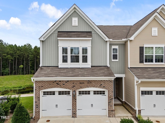 1151 Epiphany Rd, Morrisville, NC 27560 - view of front facade with board and batten siding, an attached garage, brick siding, and driveway