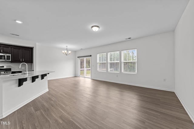 1151 Epiphany Rd, Morrisville, NC 27560 - unfurnished living room featuring a chandelier and wood finished floors