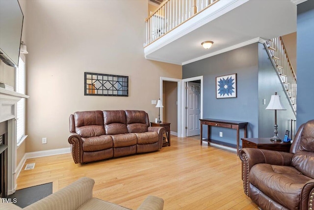 509 Spruce Meadows Ln, Willow Springs, NC 27592 - living room featuring wood finished floors, a high ceiling, a fireplace, stairway, and baseboards