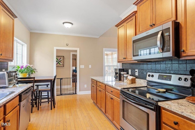 509 Spruce Meadows Ln, Willow Springs, NC 27592 - kitchen with stainless steel appliances, tasteful backsplash, crown molding, light wood finished floors, and healthy amount of natural light