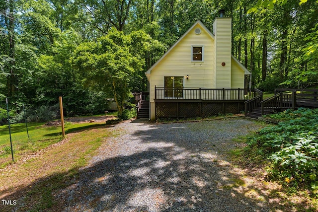 106 Redbud, Pittsboro, NC 27312 - view of front of house with a deck, stairway, and a chimney