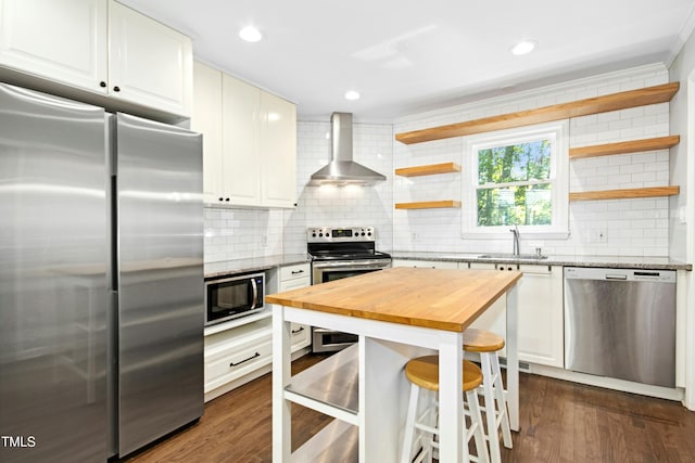 6912 Baywood Dr, Raleigh, NC 27613 - kitchen with appliances with stainless steel finishes, wall chimney exhaust hood, wood counters, open shelves, and tasteful backsplash