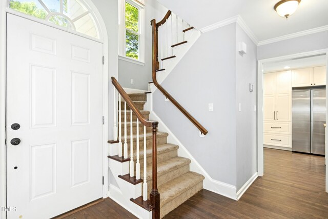 6912 Baywood Dr, Raleigh, NC 27613 - entryway with dark wood-type flooring, baseboards, ornamental molding, and stairway
