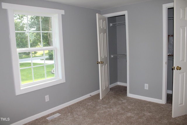 10180 Buffalo Rd, Clayton, NC 27527 - unfurnished bedroom featuring multiple windows, carpet, and baseboards