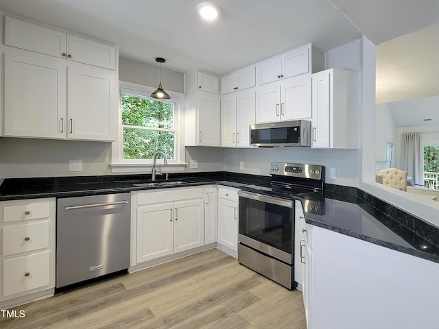 107 Long Shadow Ln, Cary, NC 27518 - kitchen featuring appliances with stainless steel finishes, a sink, white cabinets, light wood-style flooring, and dark stone counters