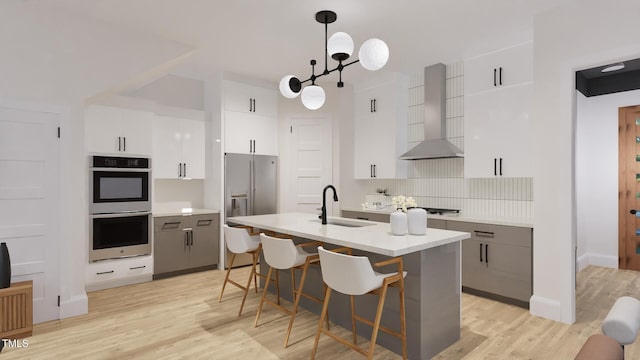 1806 Pershing Rd, Raleigh, NC 27608 - kitchen featuring wall chimney exhaust hood, a sink, appliances with stainless steel finishes, light wood-style floors, and light countertops